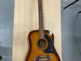 une guitare accrochée au mur à côté d'un étui à guitare