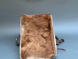 a small bag with a fur inside of it on a blue surface