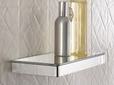 a glass shelf with a bottle of liquid and a soap dispenser on it