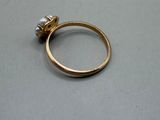 a gold ring with a pearl on it on a table