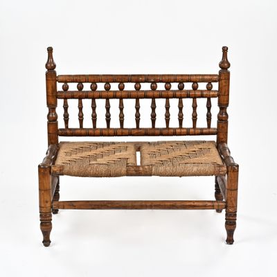un banc en bois sur lequel est posé un coussin d'assise tressé