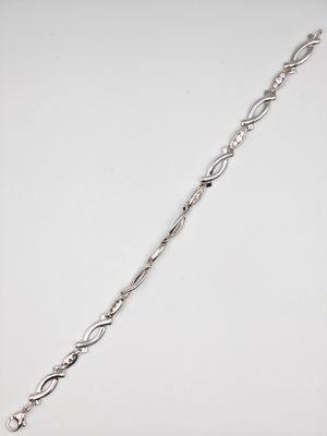 gros plan d'un bracelet en argent sur une surface blanche