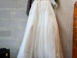 a wedding dress hanging on a wall next to a suitcase