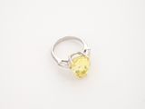 an oval yellow sapphire and diamond ring on a white surface