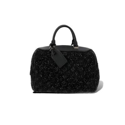 un sac à main noir posé sur une surface blanche