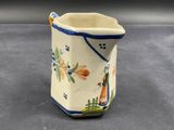 a small pitcher with a design on it on a table