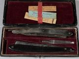 a box with a knife, a razor and a razor blade in it