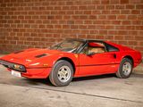 a red sports car parked in front of a brick wall