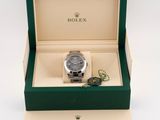 a close up of a watch in a box on a white surface