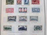 un livre ouvert, couvert de timbres, posé sur une table