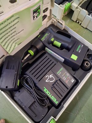 une perceuse à fil noire et verte dans une boîte