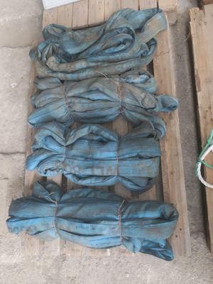 une pile de jeans posée sur une palette, à côté d'une paire de chaussures