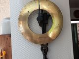 a clock hanging on the wall with a hook attached to it