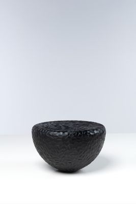 une photo d'un bol noir posé sur une table blanche