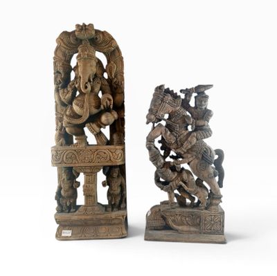 pair of carved wooden sculptures of a hindu god and a demon