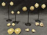 a lot of gold jewelry on display on a black table