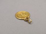 a close up of a gold coin on a white surface