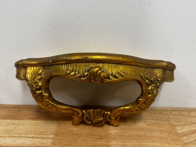 a gold plate with a handle on a wooden table