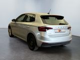 the rear end of a silver car parked in a white room