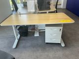 an office desk with a computer on top of it in a room