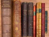 de nombreux livres anciens alignés les uns à côté des autres sur une étagère