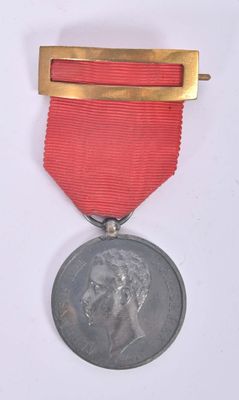 an old medal with a red ribbon on a white background