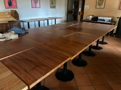 a long wooden table with black metal legs in a room