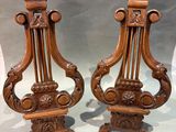 pair of carved wood candlesticks in the shape of harps