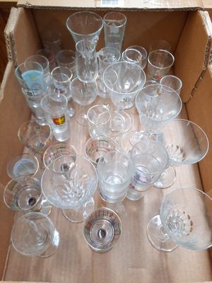 beaucoup de verres vides dans une boîte posée par terre