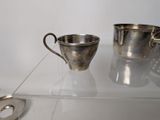 two cups and a spoon sitting on a glass shelf