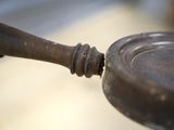 a small metal object with a wooden handle on a table