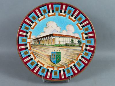une assiette décorative sur laquelle est représenté un bâtiment