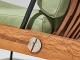 a wooden chair with a green cushion and a black metal frame