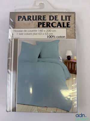 l'emballage d'un lit avec une couette bleue et des oreillers