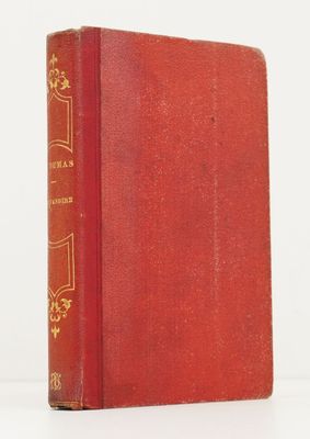 un vieux livre rouge posé sur une table blanche