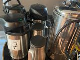 many coffee pots and cups sitting on a table
