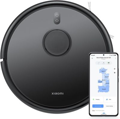 a black robot vacuum cleaner with a phone next to it