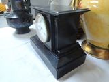 two vases and a clock sitting on a table