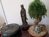 une table sur laquelle se trouvent une plante en pot et une statue
