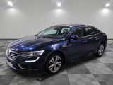une voiture bleue est garée dans une grande pièce au sol en damier