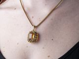 woman wearing a black top and a gold necklace with a golden pendant