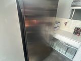 a stainless steel refrigerator in a kitchen with a window