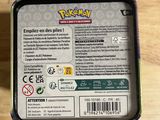 someone is holding a box of pokemon cards on a wooden table