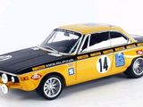 a yellow and black model of a car on a white surface