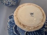 a blue and white vase sitting on a table next to another vase