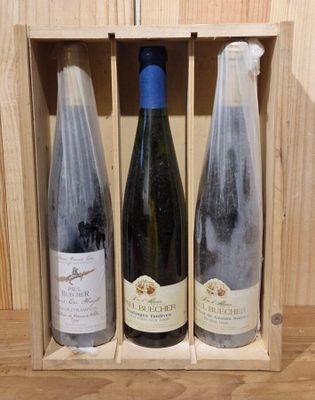 three bottles of wine in a wooden box on a table