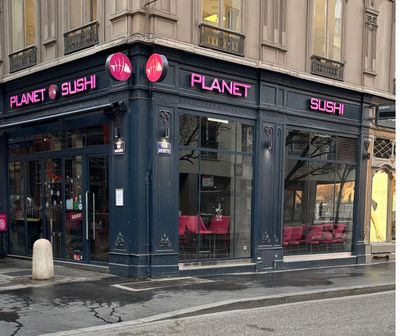 une devanture de magasin sur laquelle est accrochée une enseigne rose