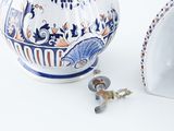 a blue and white vase and a key on a white table