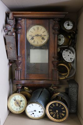 de nombreuses horloges différentes dans une boîte posée sur l'étagère