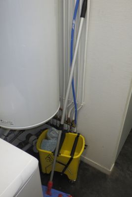 un chauffe-eau blanc et une serpillière jaune dans une pièce